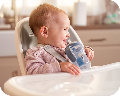 Baby in highchair with cup
